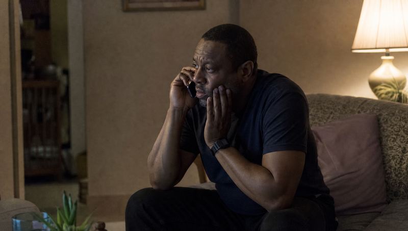 A man with a toothache on the phone at night, holding his jaw